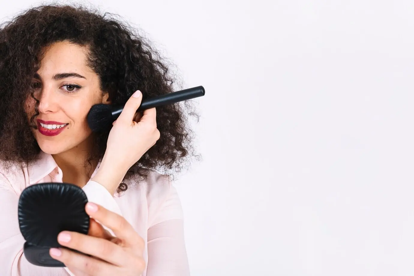 Eine charmante Frau schminkt sich.