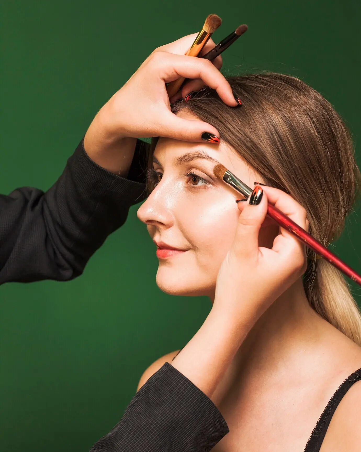Eine professionelle Frau schminkt einem Mädchen die Augen.